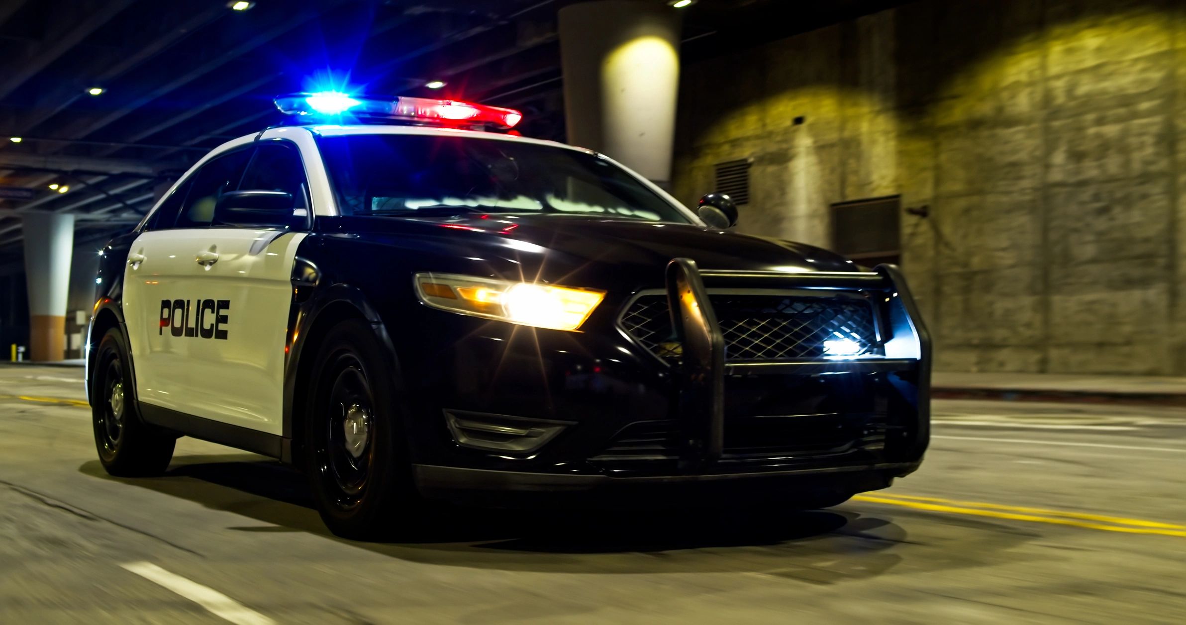 Police car with lights on at night in a city
