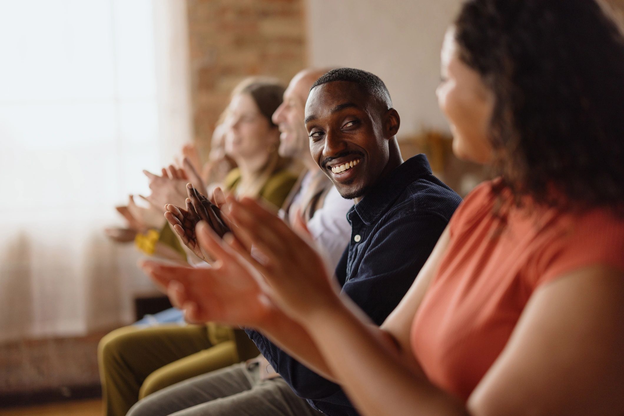 Community audience clapping at a public meeting